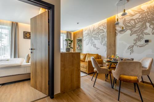 sala de estar con mesa y dormitorio en Mokka House Panzió, en Miskolc