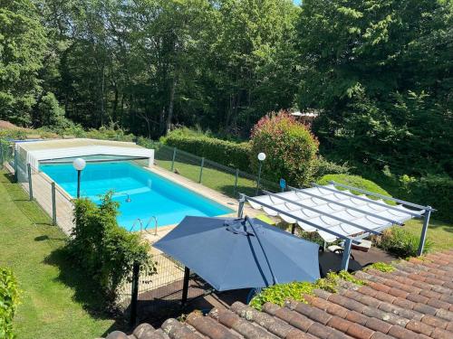 vista dall'alto di una piscina con un ombrellone di Le Mondou a Saint-Julien-de-Lampon