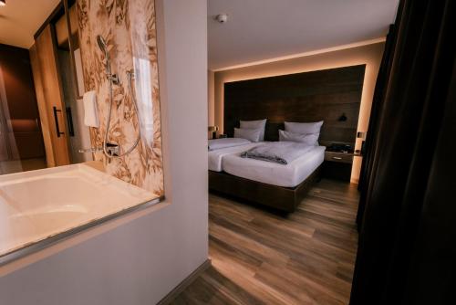 a hotel room with a bed and a bath tub at Holzapfel in Bad Füssing