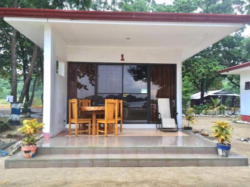 a house with a table and chairs on a porch at Bolo Hills Beach Club And Residence in Alaminos