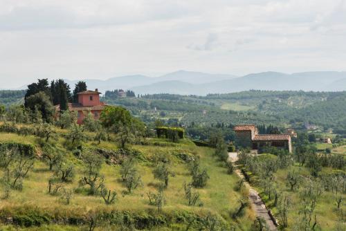 a view of a field with a house on a hill at Casavilla Rentals by Torre a Cona in Rignano sullʼArno