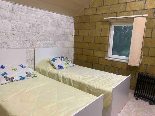 Habitación con 2 camas y ventana en Tranquil Forest Retreat cozy Cottage near Sevan, en Sevan