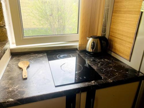 a kitchen counter top with aettle and a window at Tranquil Forest Retreat cozy Cottage near Sevan in Sevan