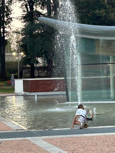a young boy sitting in front of a fountain at In centro da Ale in Seregno