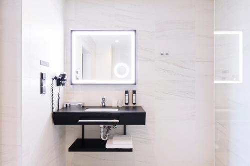 a bathroom with a black sink and a mirror at Grand Ascot Hotel in Kraków