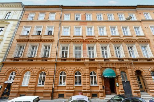 a large wooden building with white windows on a street at Kalvin House Budapest in Budapest