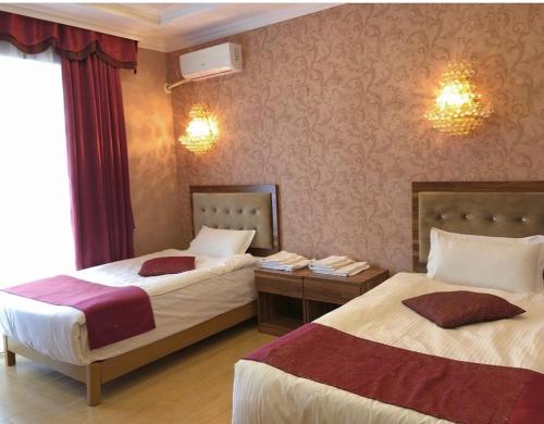 a hotel room with two beds and a window at Royal_hotel_hostel in Aktobe