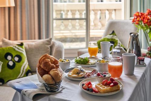 einen Frühstückstisch mit Speisen und Getränken in der Unterkunft Paris Marriott Opera Ambassador Hotel in Paris