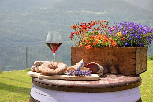 a table with a glass of wine and flowers at Il posto al sole in Teglio