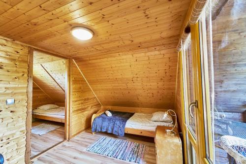 a small room with a bed in a wooden cabin at Marel - apartments Domek Kołodziejówka Polanica Zdrój in Polanica-Zdrój