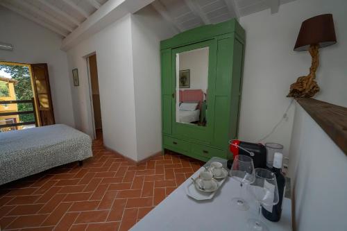 PeccioliにあるAgriturismo La valleの緑のキャビネットとベッド付きのベッドルーム1室