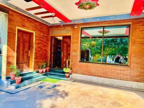 a brick building with a door and some potted plants at Infinity Hotel in Lahore