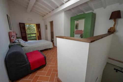um quarto com uma cama, um sofá e um espelho em Agriturismo La valle em Peccioli