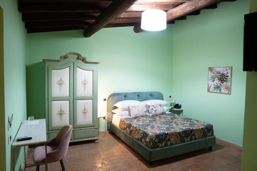 a bedroom with a bed and a cabinet and a desk at Relais Santa Caterina Hotel in Viterbo