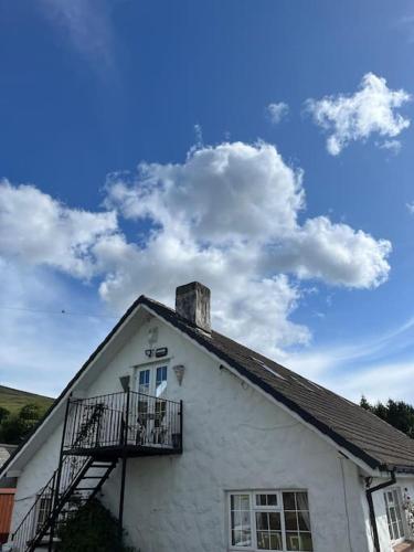 a white building with a balcony and a sky at Kylemore Lakeview Retreat in Blessington