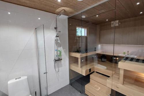 een badkamer met een douche, een toilet en een wastafel bij Kotimaailma Apartments Sääksmäentie in Jyväskylä