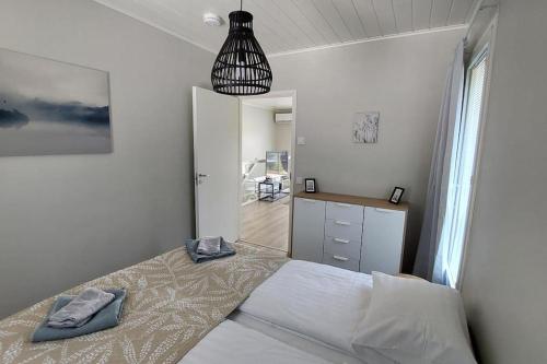 a bedroom with a bed and a pendant light at Kotimaailma Apartments Sääksmäentie in Jyväskylä