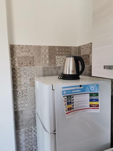 a tea kettle is sitting on top of a refrigerator at Santa Luria Casa dolce Casa in Santa Luria