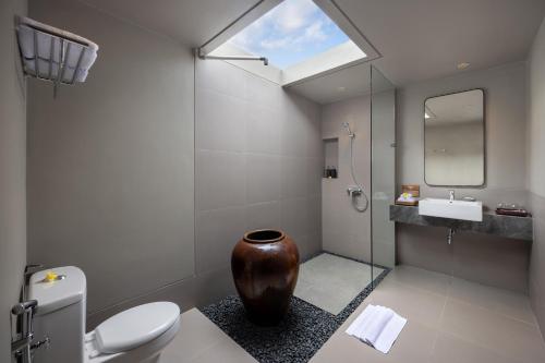 a bathroom with a toilet and a sink and a mirror at Tapa Agung View in Menanga