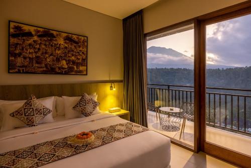 a bedroom with a bed and a balcony with a view at Tapa Agung View Besakih in Menanga