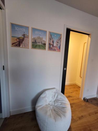 a room with a white wall with pictures on the wall at Villa Oriel 1 à NEUFCHATEL-HARDELOT avec piscine privée in Neufchâtel-Hardelot