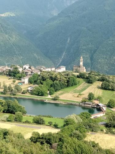 a view of a town with a lake and mountains at Il posto al sole in Teglio