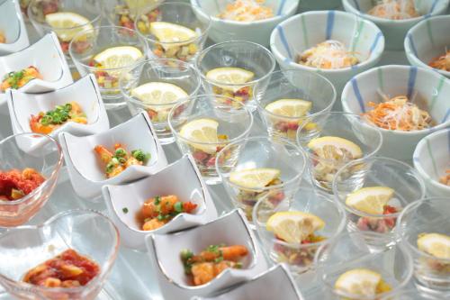a table with many cups of food in bowls at Spa and Resort Hotel Solage Oita Hiji Beppuwan in Beppu