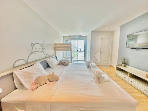 a bedroom with a large bed with stuffed animals on it at Herma Hotel in Samutprakarn