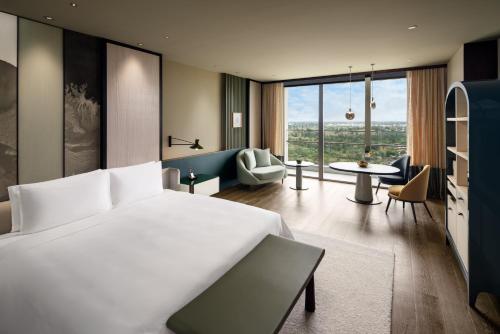 a bedroom with a large bed and a living room at New World Hoiana Beach Resort in Hoi An