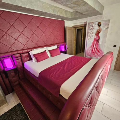 a bedroom with a large bed with purple lights at Olympic Wellness & Spa Apartments in Belgrade