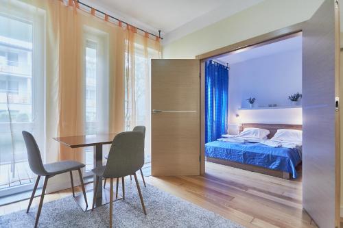 1 dormitorio con 1 cama, mesa y sillas en Baltycka 10 by Baltic Home, en Świnoujście