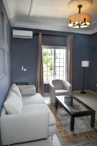 a living room with a white couch and a coffee table at Riad Prince Louis in Yaoundé