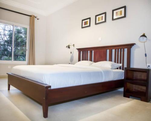 a bedroom with a large bed and a window at Riad Prince Louis in Yaoundé