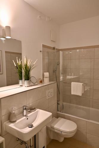 Un baño con lavabo, inodoro y ducha. en Modernes Apt mit direkter Anbindung zur City und Messe, en Hannover
