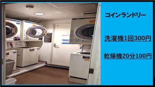 a laundry room with washing machines and a door at 小牧シティホテル in Komaki