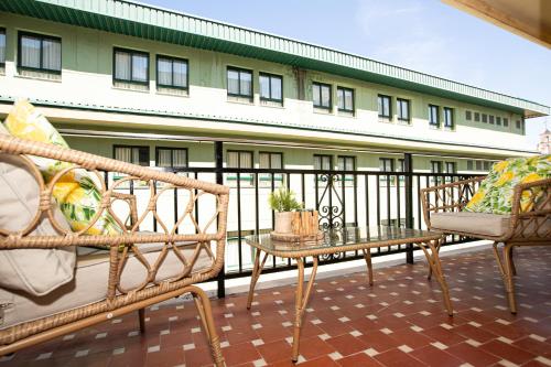 a balcony with two benches and a table and a building at Apartamento La Luz by Clabao in Denia