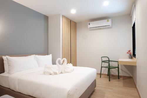 een slaapkamer met een wit bed en een bureau bij Maleesa Place Hua Hin in Hua Hin