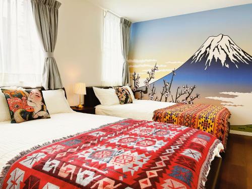 two beds in a room with a mountain mural on the wall at Tokyo Private villa/near station/Ginza/Asakusa/Sky Tree/Louis House in Tokyo