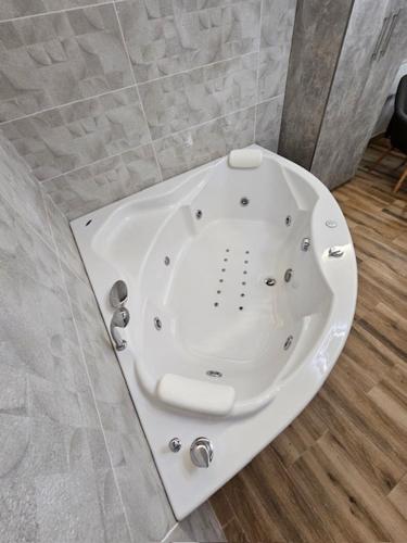 a white bath tub in a bathroom at Olympic Wellness & Spa Apartments in Belgrade