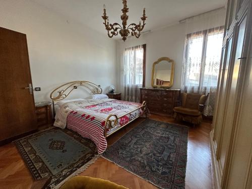 una camera con letto, cassettiera e specchio di ELEGANTE Villa NAKHIL con jacuzzi a Spinea