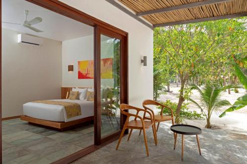 um quarto com uma cama, uma mesa e cadeiras em ISLAND CENTER POINT em Koh Rong Sanloem