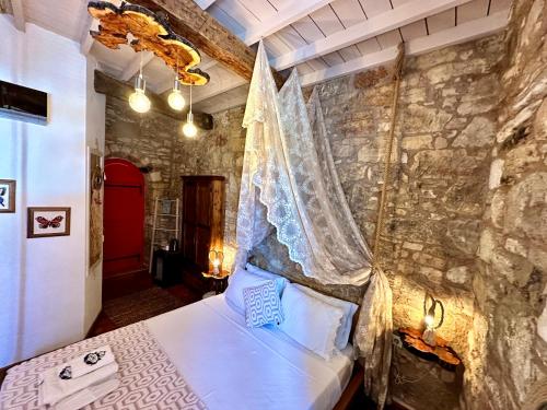 a bedroom with a bed with a stone wall at Marissa Boutique Hotel in Çeşme