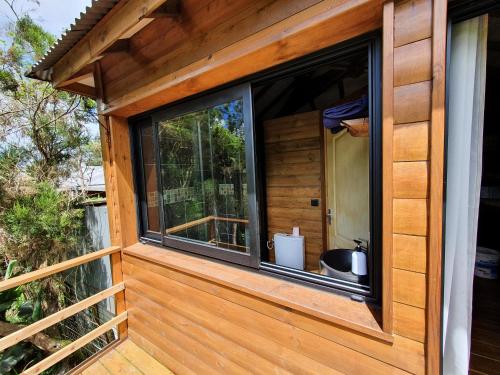 a window on the side of a wooden house at Les Balsamines chez Michèle & Daniel in La Plaine des Palmistes