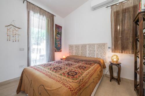 a bedroom with a bed in a room with a window at Casa Cò in Costa Rei