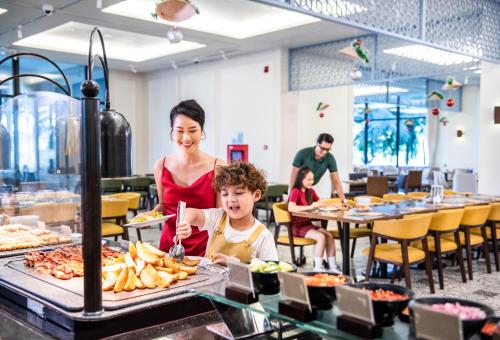 une femme et un enfant mangeant dans un restaurant dans l'établissement Vinpearl Wonderworld Phu Quoc, à Duong Dong