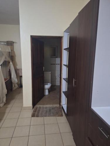 baño con aseo y puerta de madera en HomeAway_Luxurious Malindi en Malindi