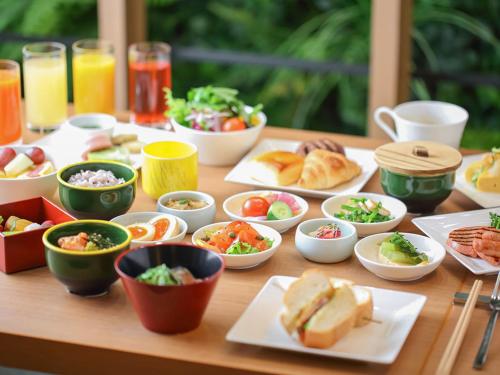 uma mesa com pratos de comida e tigelas de comida em Solaria Nishitetsu Hotel Kyoto Premier em Quioto