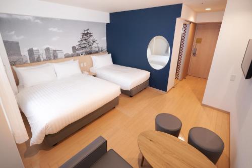 大阪市にあるトラベロッジ本町大阪のベッドと椅子付きの小さな部屋です。