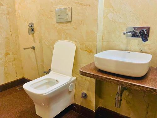a bathroom with a toilet and a sink at Qotel Hotel Pitampura Couple Friendly in New Delhi
