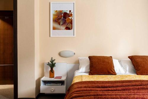 a bedroom with a bed and a night stand with a lamp at Meublè La Betulla in Chiesa in Valmalenco